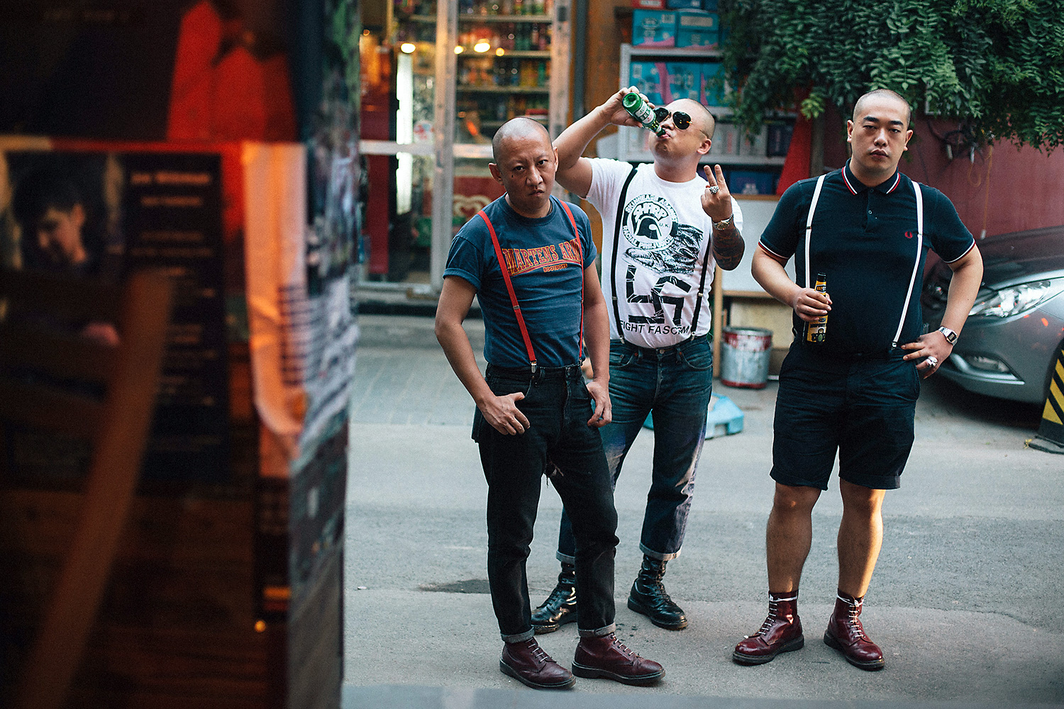 Ma Ke a.k.a. ‘Mr. Ma,’ Yan Lei a.k.a. ‘Bangbang,’ and ‘TM©’ pose on a Beijing street for a portrait. (TM© asked not to reveal his real name.) Bangbang flashes a ‘V’ in defiance while wearing a t-shirt from the anti-fascist punk movement Skinheads Against Racial Prejudice (SHARP), that depicts a punk-rock favorite Dr. Martens boot stomping a Nazi swastika.