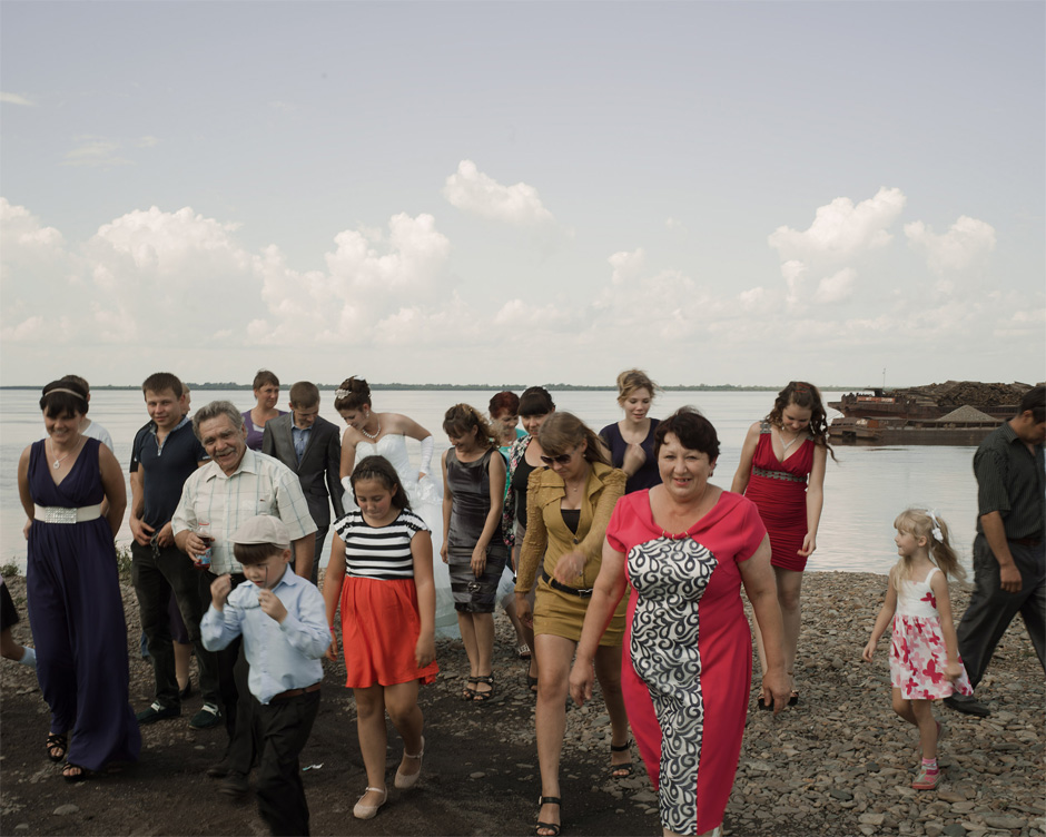 A Russian bride and groom celebrate with members of their wedding party on the banks of the Amur River in Troitskoye, Khabarovsk Krai.