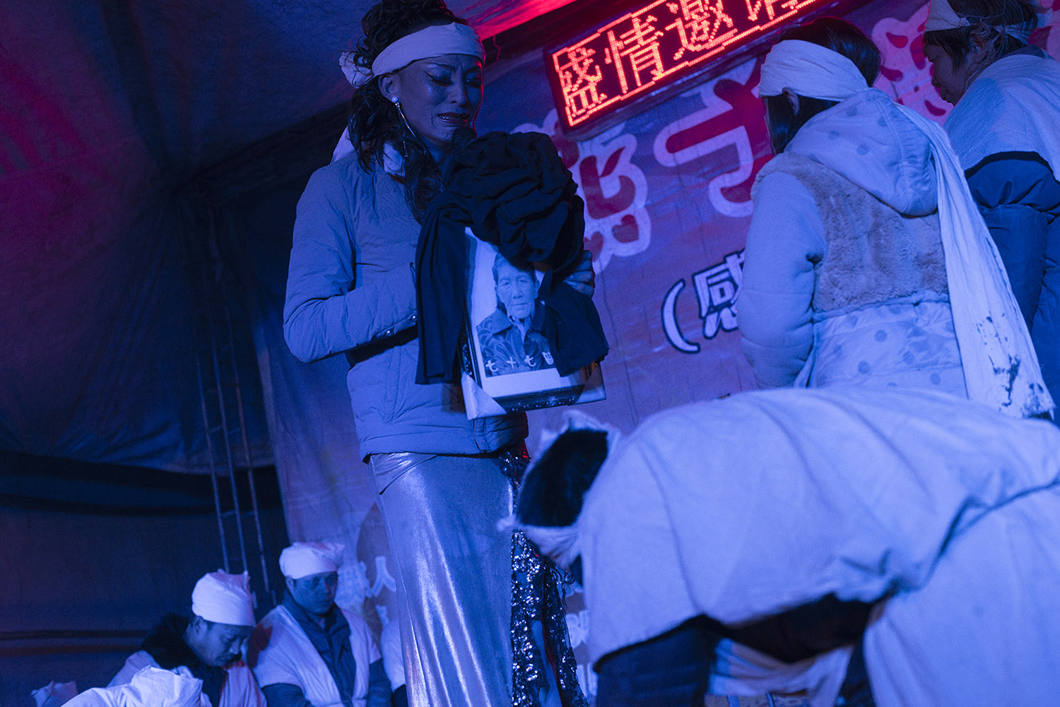 Liangzi holds a portrait of a deceased woman and wails, January 28, 2015. 