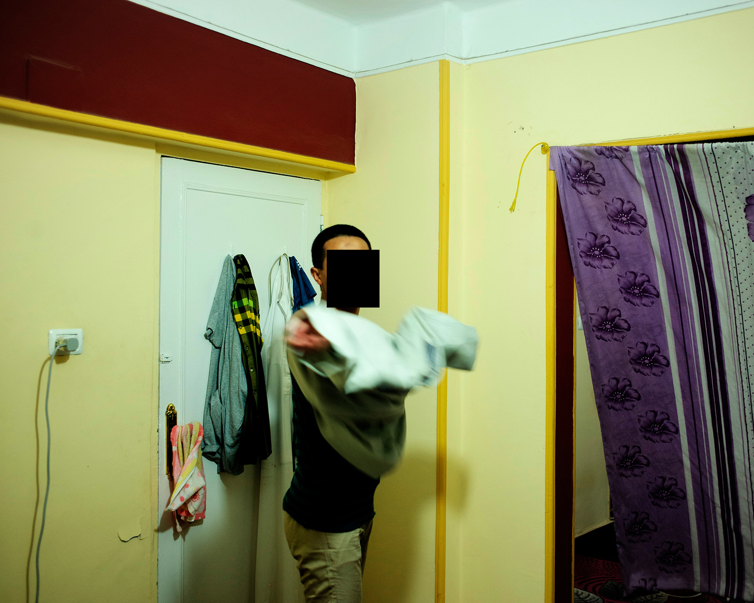 Ibrahim, who is Hui and was born in Linxia Hui Autonomous Prefecture of Gansu province, puts on a thobe before a prayer in his dormitory, in Cairo, Egypt, May 2017. Ibrahim traveled to Cairo in the beginning of 2017 and started Arabic language classes in preparation for applying to college. His goal was to attend the famed Al-Azhar University in Cairo. However, he never managed to return to Cairo after a trip back home during Ramadan in the same year.