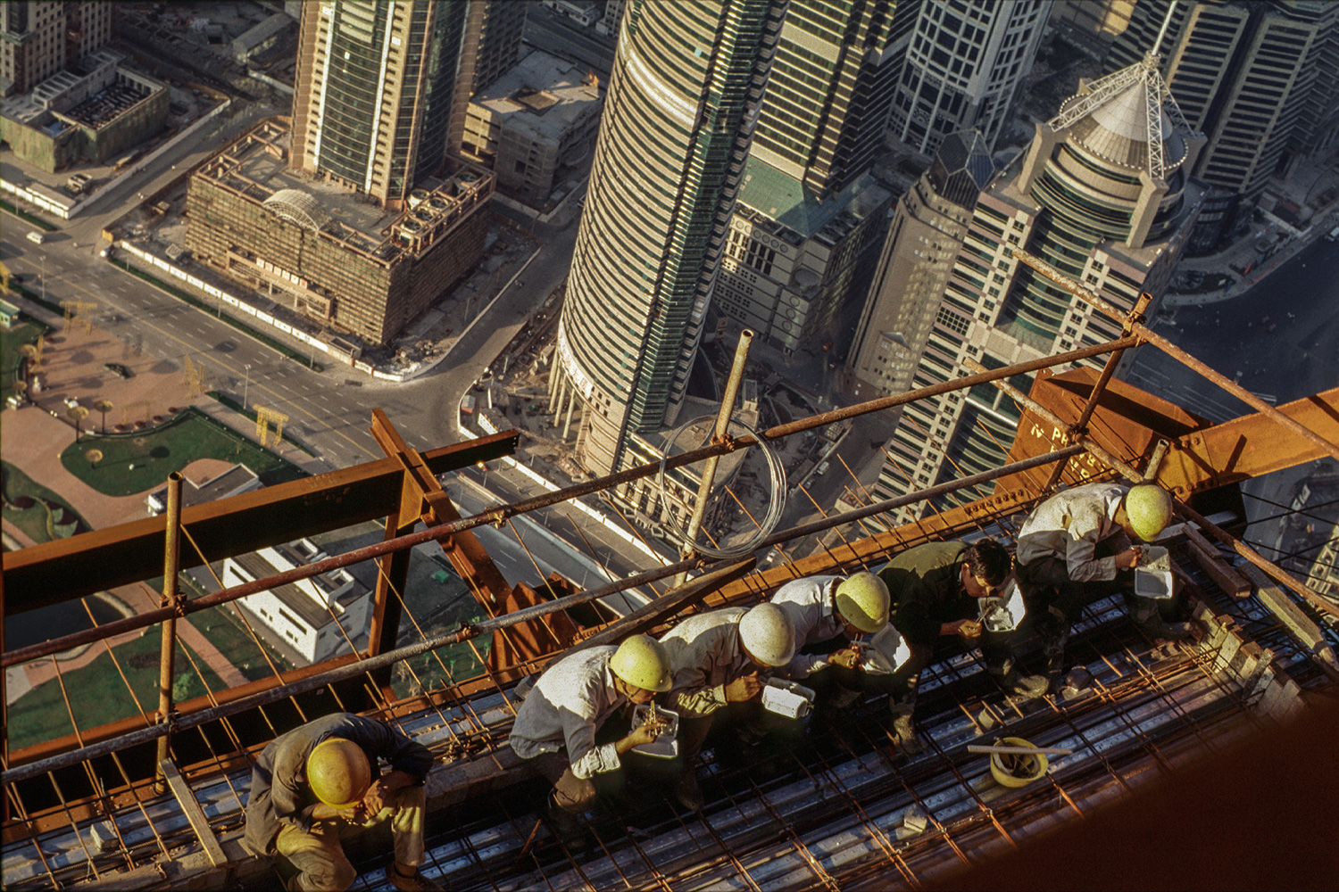 Construction workers take a break to eat boxed dinners high up on Jin Mao Tower, overlooking central Lujiazui, 1997.