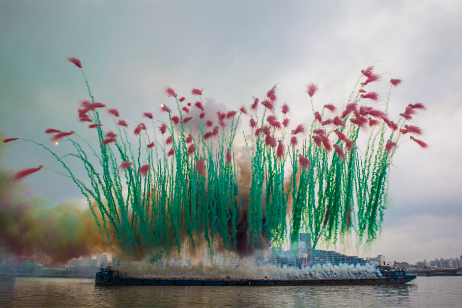 Red and green pyrotechnics explode as part of ‘Remembrance,’ part two of “Elegy: Explosion Event for the Opening of Cai Guo-Qiang: The Ninth Wave,” on the riverfront of the Power Station of Art gallery, August 8, 2014. (Photo by Lin Yi, courtesy Cai Studio)