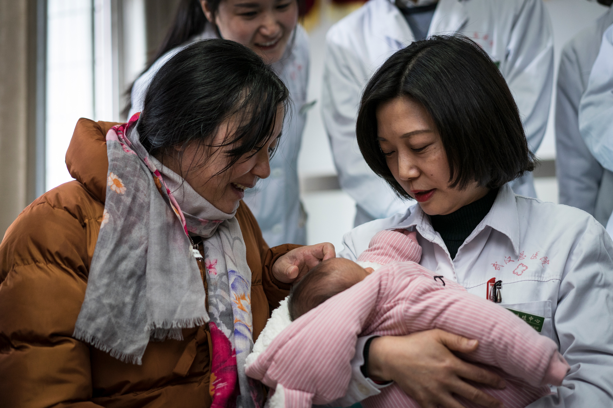 After “zuo yue zi,” or “sitting the month”––a Chinese tradition of restricting diet and activities for the first month after a woman gives birth––Zhiying and Fangguo bring the twins to the doctor who helped them with IVF, and express their gratitude, January 9, 2018.  