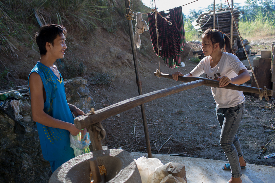Ming and Cai use a neighbor’s hand mill to grind corn. Courtship is brief and much of the relationship building happens when the young couples are already married.