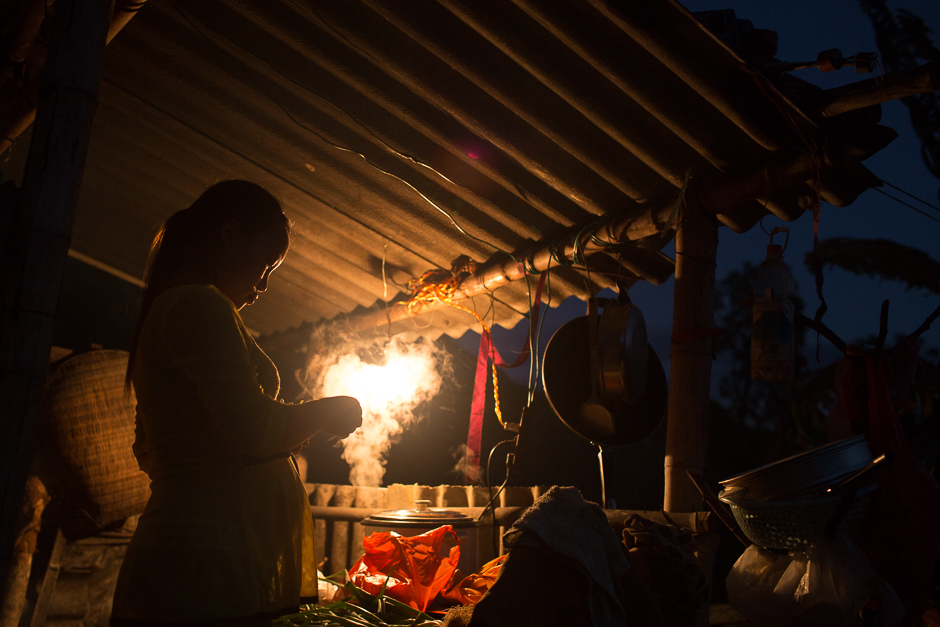 Jie cooks dinner in her in-laws’ outdoor kitchen. She lives in their house with her husband, in Tangzibian village, Mengla county. Her in-laws work in Anhui province as migrant workers, leaving the couple alone in the village. The money they send back every month is the only income for the young couple.