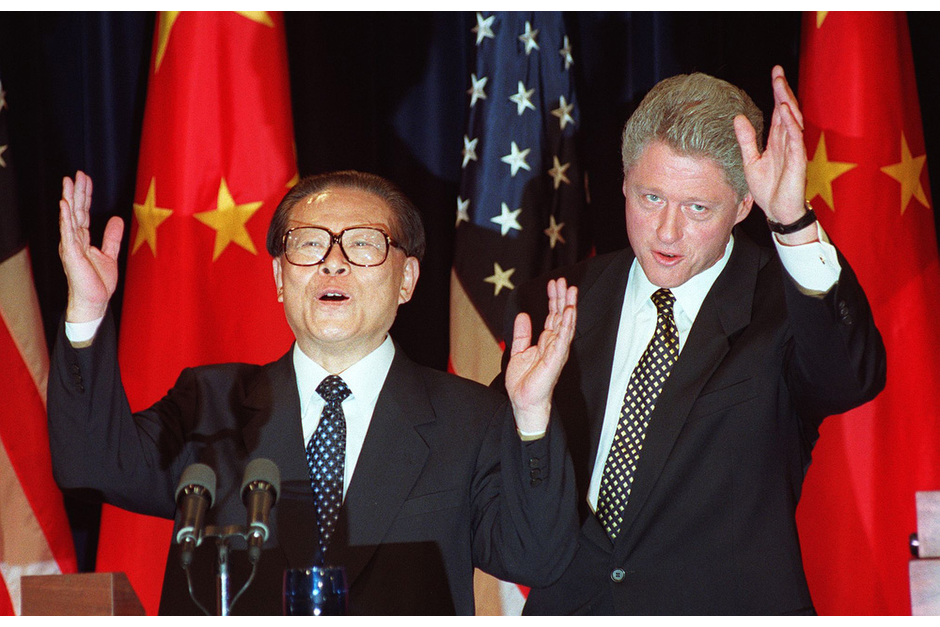 Chinese President Jiang Zemin and U.S. President Bill Clinton wave at the end of their joint press conference, October 29, 1997, at the Old Executive Office Building next to the White House. Jiang came to power in the aftermath of the Tiananmen massacre, an event which caused tense relations between the two countries in the ensuing years. (Photo by Joyce Naltchayan/AFP/Getty Images)