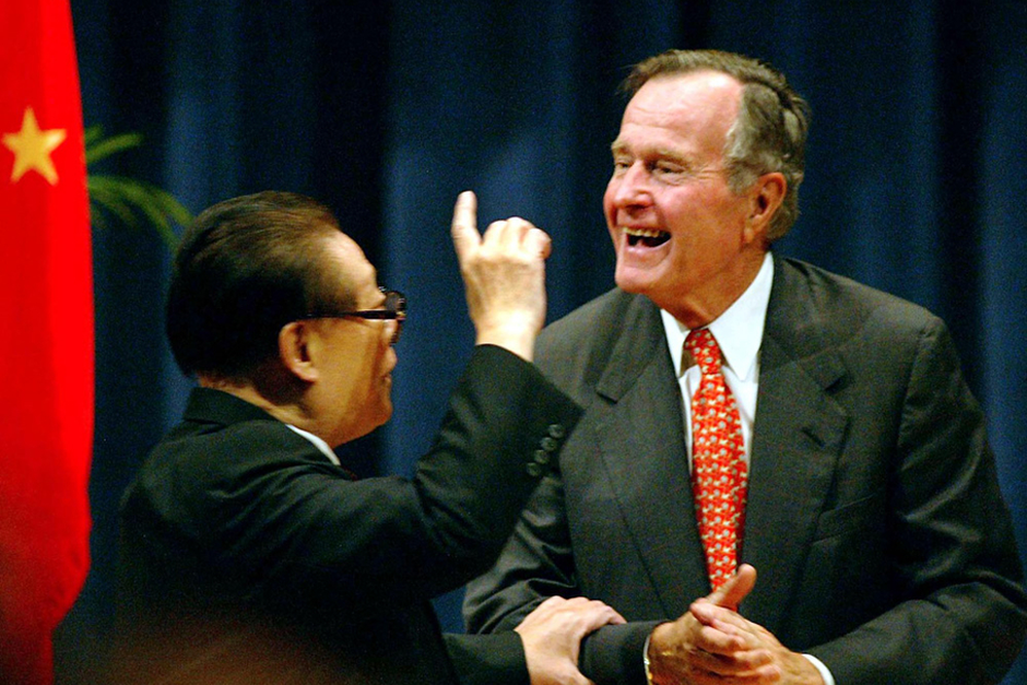 Chinese President Jiang Zemin and former U.S. President George Bush communicate following Jiang’s speech at the George Bush Presidential Conference Center on the campus of the Texas A&M University in College Station, Texas, October 24, 2002. (Photo by Paul Buck/AFP/Getty Images)