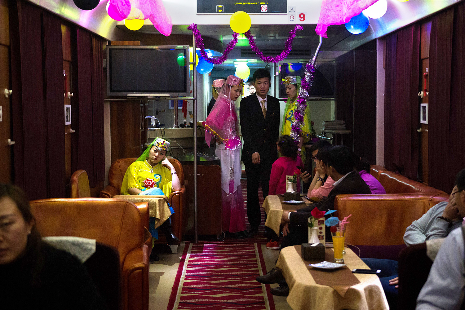 Railway staff dressed in traditional Hui-style outfits wait to perform a dance for the passengers in the dining car of a train bound for the autonomous region of Ningxia.