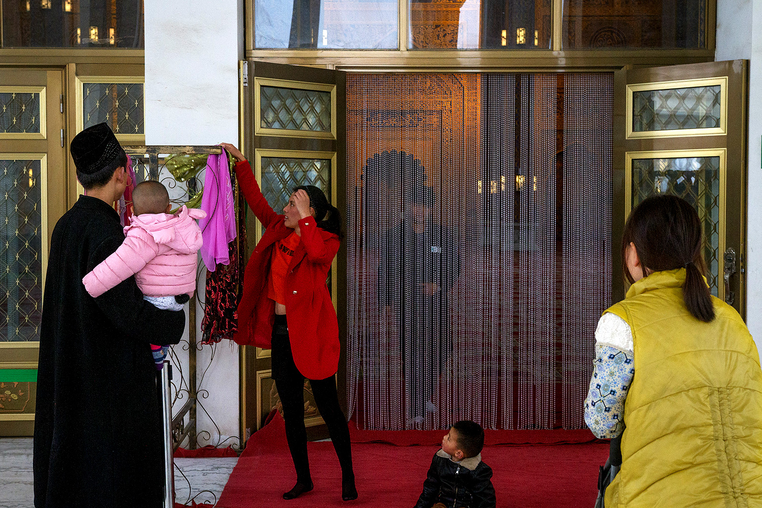 A visitor picks out a headscarf to wear before entering the Golden Palace.