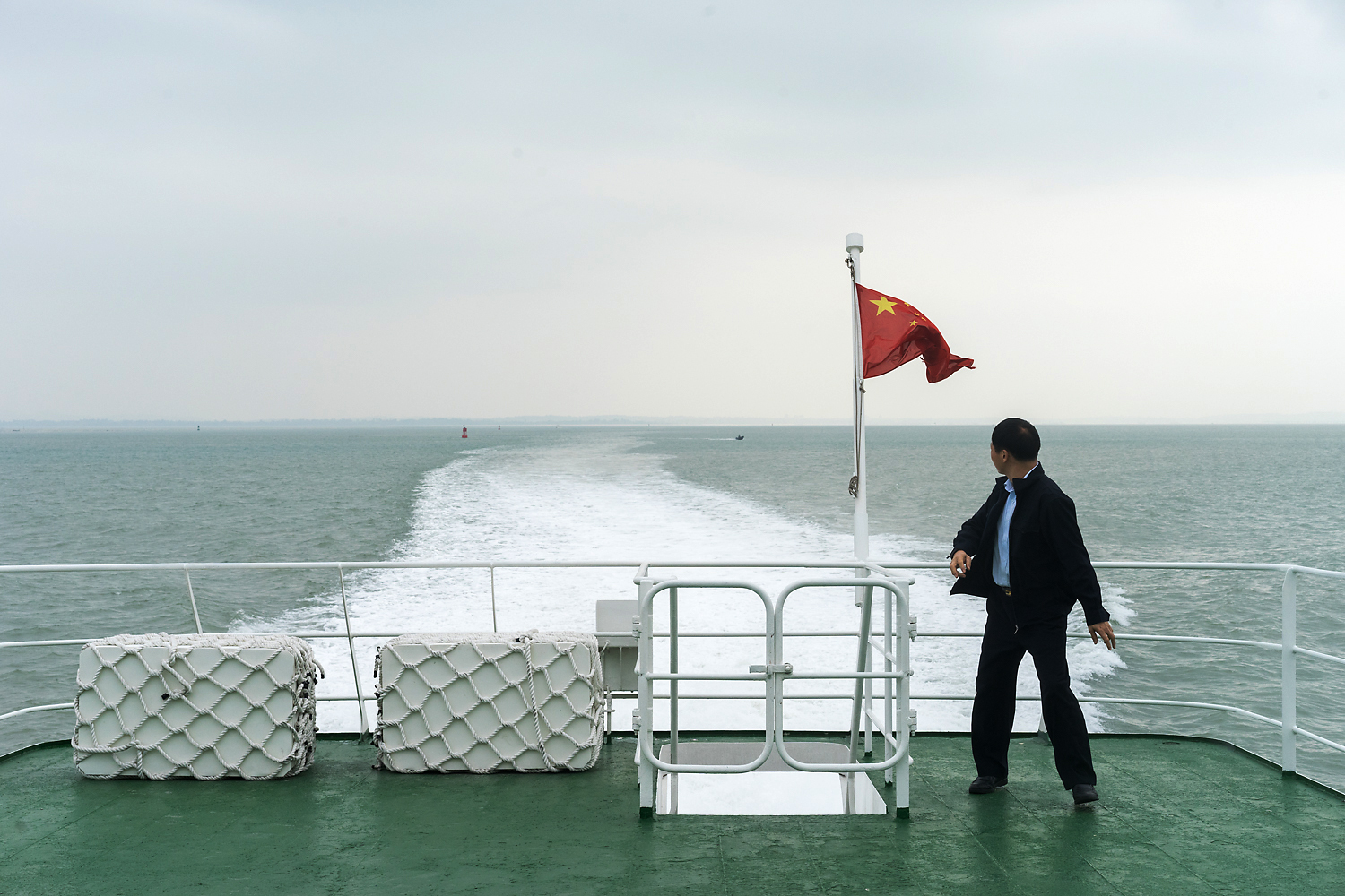 The Chinese flag flies from the stern of a Xiamen-run ferry passing through Chinese waters on a return trip from Kinmen. The ferries that ply the Taiwan Strait are run alternately by Xiamen and Kinmen ships. Although China does not officially recognize Taiwan, and continues to see it as a renegade province, there is an unwritten understanding between the ferry companies on both sides. The Chinese and Taiwanese flags are lowered at the midway point and flown again only when the ships are back in their respective territories.