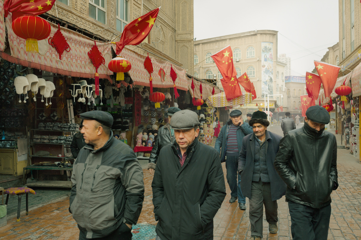 Uyghur men walk down a commercial street near the Id Kah Mosque, in Kashgar’s Old City, January 31, 2019.