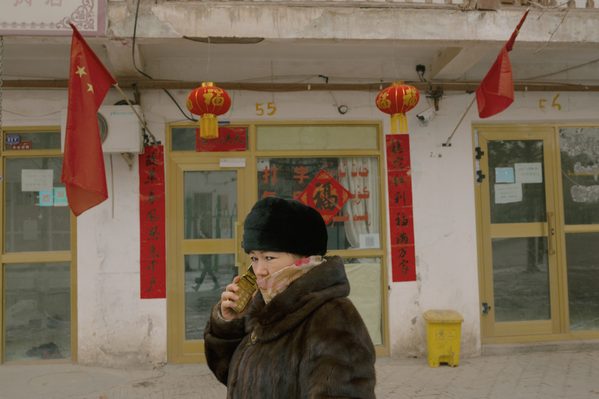 A woman talks on the phone while walking down a street in Kashgar’s Old City, January 31, 2019.