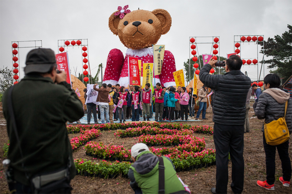 Wang Bao-xuan, the candidate representing the union of the Green Party and the Social Democratic Party, gathers with supporters around a teddy bear called “Nüyingxiong,” a mascot for a protest against an expansion of Taoyuan International Airport that would displace 40,000 farmers.