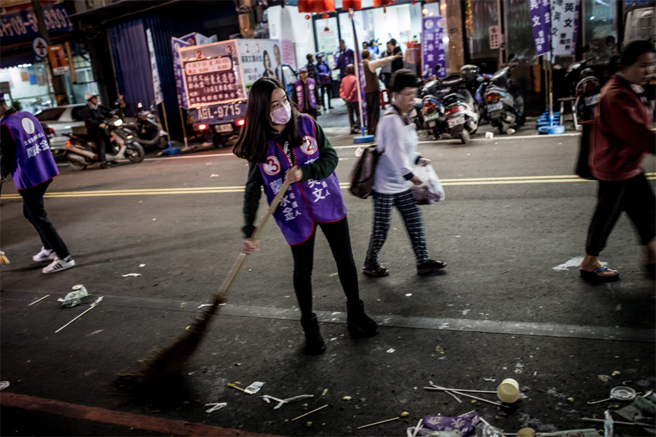 A DPP campaign worker sweeps the street after a rally for Legislative Yuan candidate Zheng Yong-jin and presidential candidate Tsai Ying-wen in Zhudong, Hsinchu County.