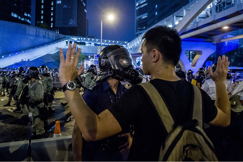 A pro-democracy protester faces a policeman. (Photo by Xaume Olleros/AFP/Getty Images)