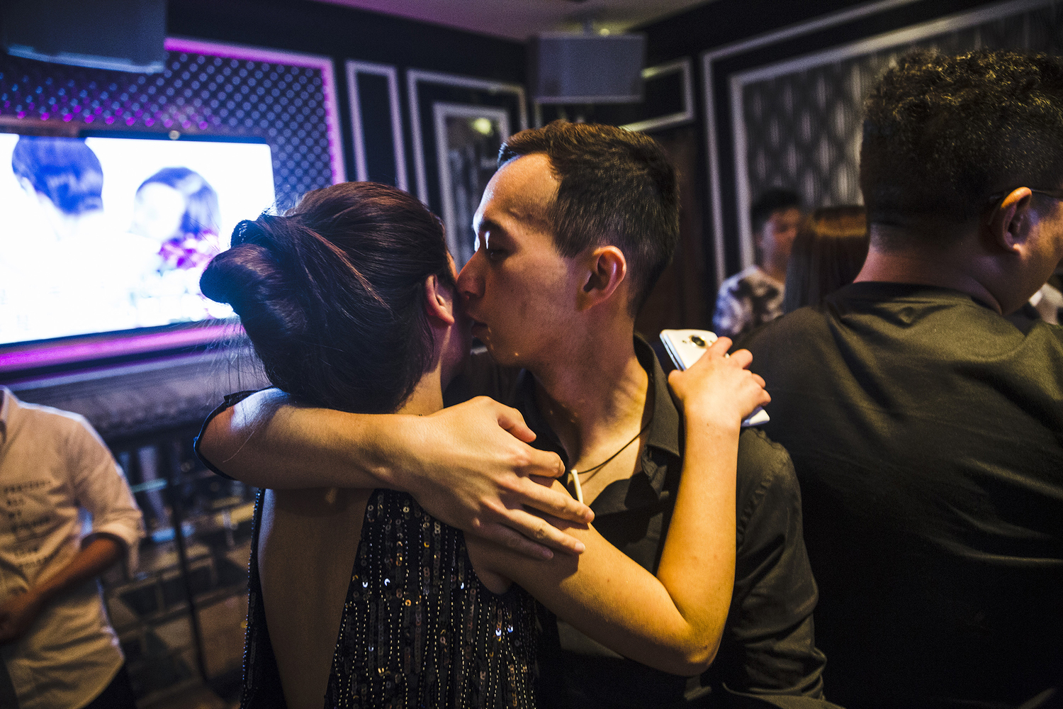 A student kisses a woman he met on the dating app Tantan, at a karaoke parlor, May 18, 2015. The students’ final exam involves inviting at least two women they meet in the real world or on Tantan to a party at a karaoke parlor.