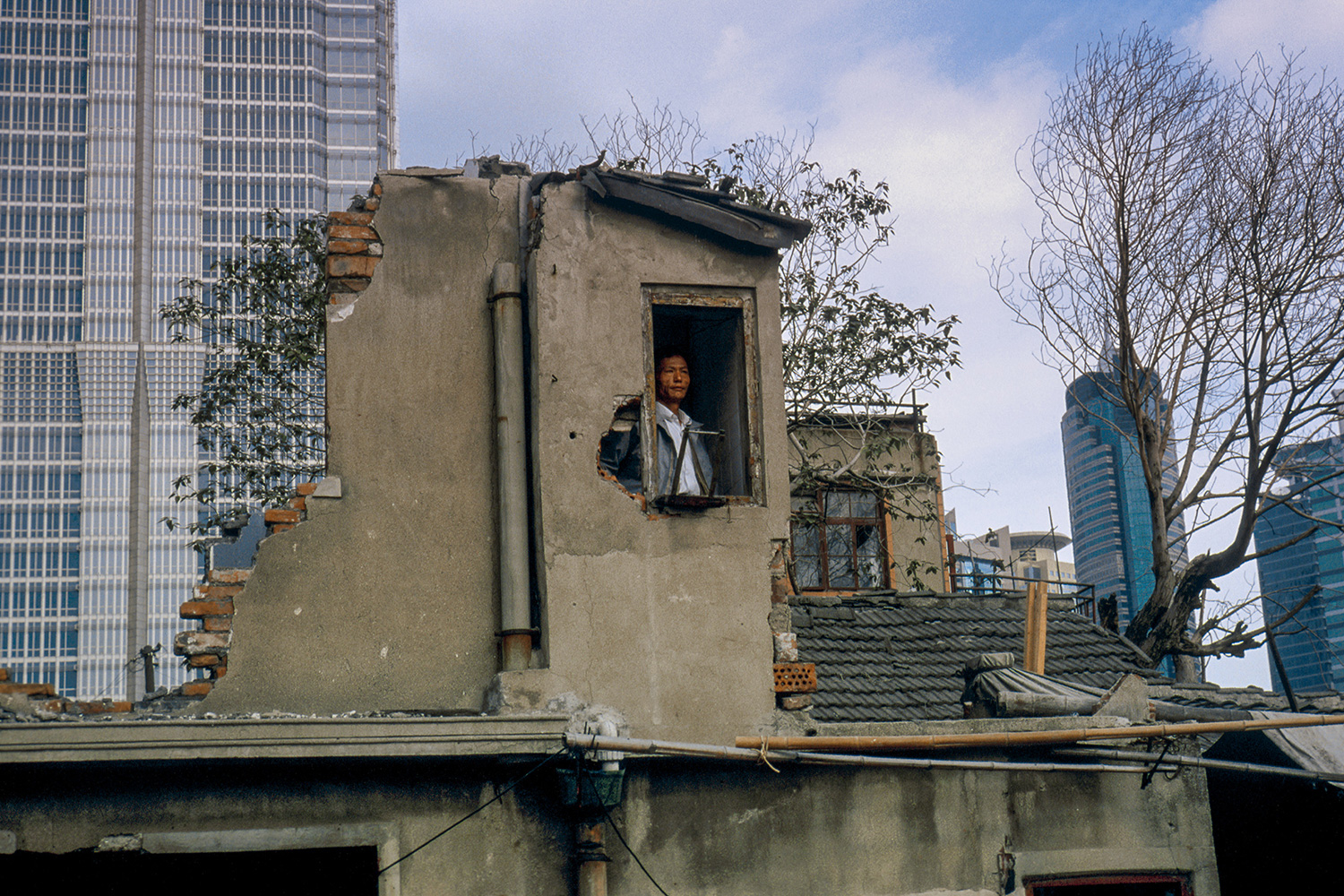 A resident refuses to leave his home at the base of the Jin Mao Tower, 1998.