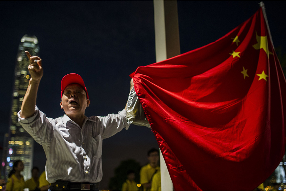 A pro-Beijing demonstrator holds a Chinese flag and shouts to pro-democracy activists in Tamar Park on September 26. (Photo by Xaume Olleros/AFP/Getty Images)