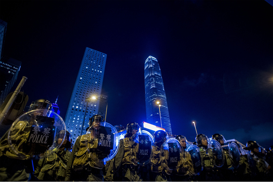 Police officers stand in front of pro-democracy protesters. (Photo by Xaume Olleros/AFP/Getty Images)
