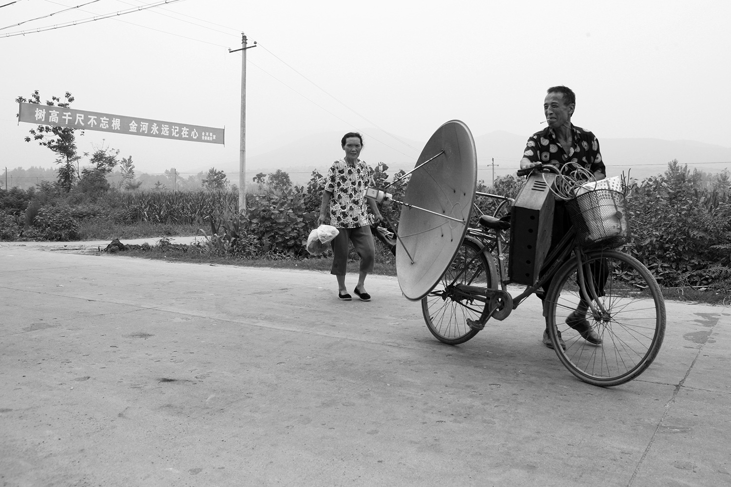 A farmer brings his dismantled TV antenna equipment with him as he leaves Jinhe. Nearly all material goods, with even the slightest bit of worth, were carted away; little was left behind.