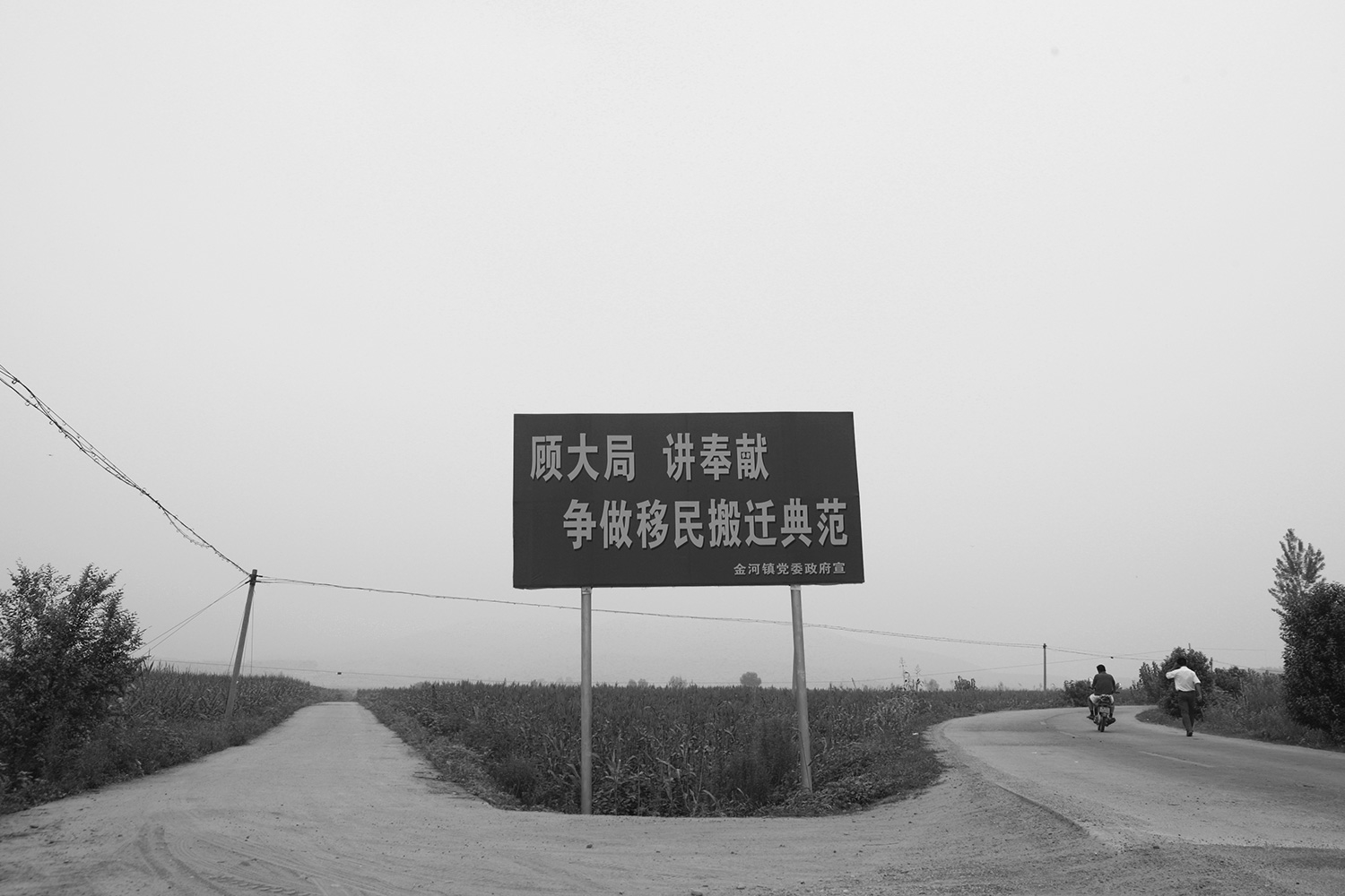 Slogans like this one, which reads “Look at the Big Picture, Be Willing to Sacrifice, Strive to Become an Exemplary Migration Town,” are all over the resettled area, urging farmers to demolish their houses.