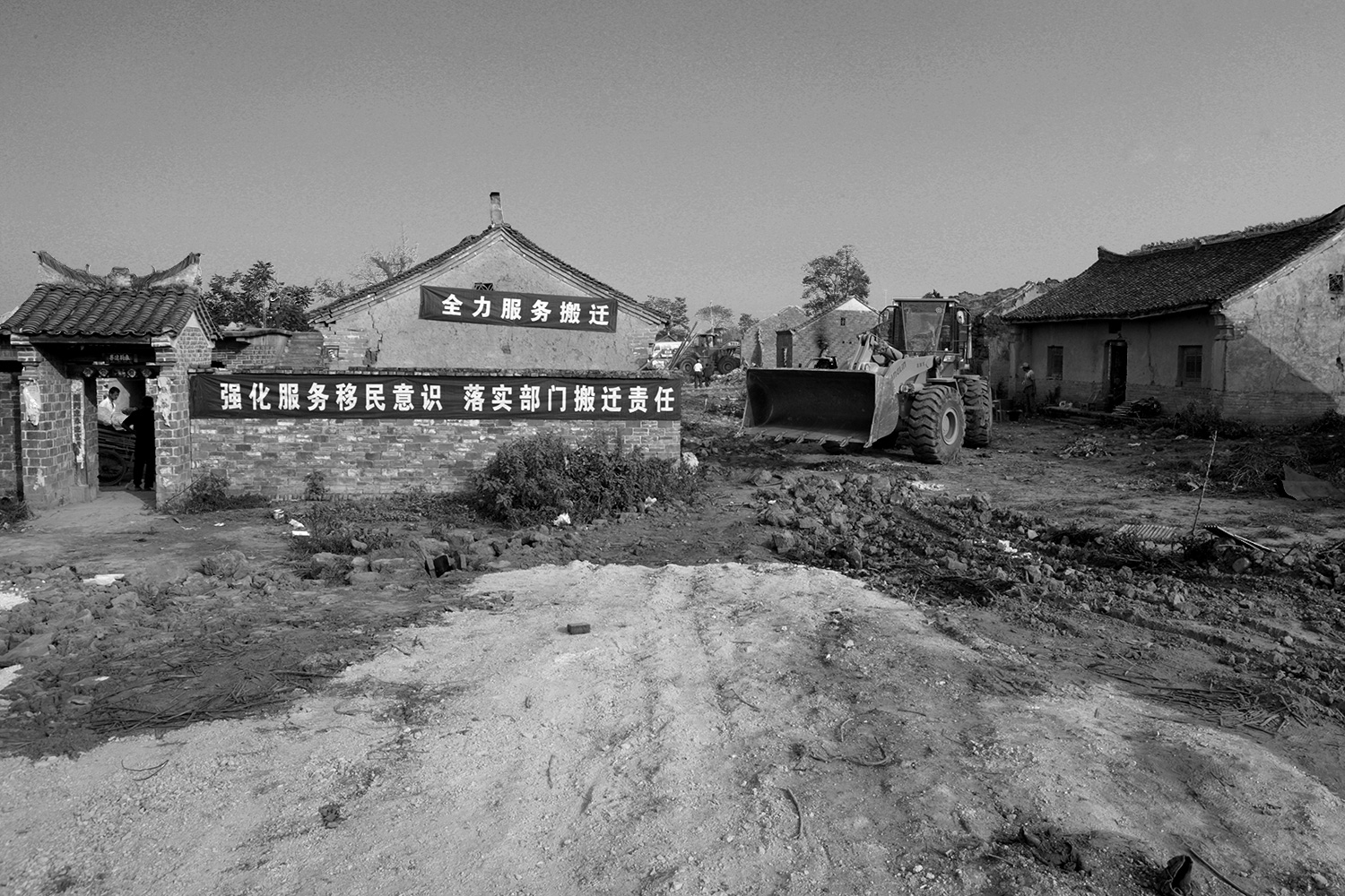With the village largely empty of people, a bulldozer flattens a piece of ground in the village of Jinhe, August 2011.